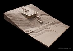 an architectural model of a house in the middle of a black area with waves on it