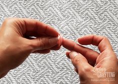 two hands are touching each other on a piece of fabric that has been stitched together