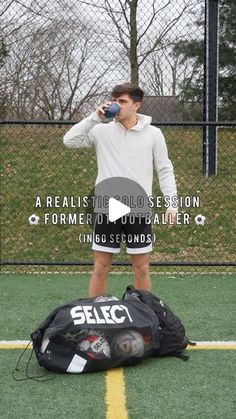 a man standing on top of a soccer field holding a water bottle in his hand