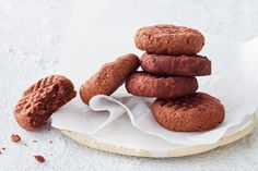 a pile of cookies sitting on top of a white paper towel next to some nuts