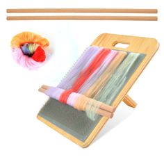 a pair of knitting needles next to a weaving kit