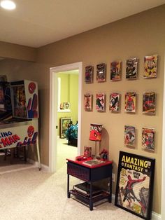 a living room filled with comic books and posters on the wall next to a doorway