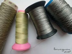 three spools of thread sitting next to each other on top of a table