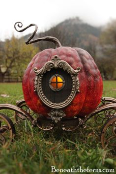 a red pumpkin shaped like a carriage on the grass