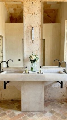 a bathroom with two sinks and a large mirror in the wall next to each other