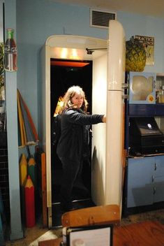 a woman standing in the doorway of a kitchen