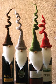 three wine bottles with gnome hats on them