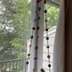 some glass beads are hanging from a window