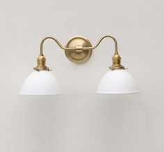 two white lamps are on the wall next to each other