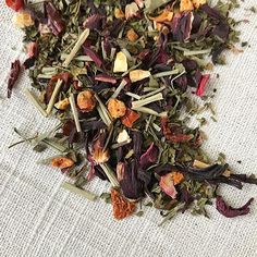 a pile of tea sitting on top of a white cloth covered in lots of different types of flowers