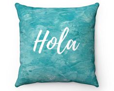 a blue pillow with the word hola written in white on it's front