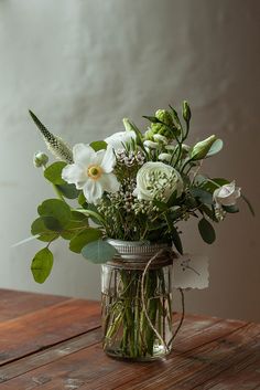 a vase filled with white flowers on top of a wooden table