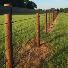 a fence in the middle of a grassy field