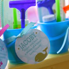 toothbrushes and toothpaste in blue buckets with name tags on them