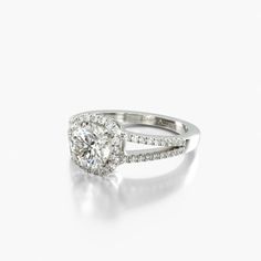 a white gold ring with diamonds on the sides and an oval shaped diamond in the center