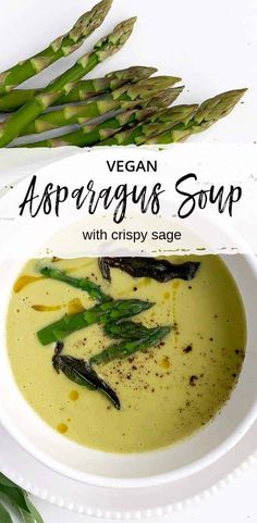 asparagus soup with crispy sage in a white bowl on a plate next to green asparagus