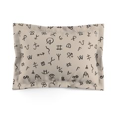 a pillow case with black letters and symbols printed on the front, along with a white background