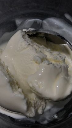 an ice cream scoop in a bowl with some white stuff on it's side