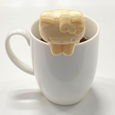 a cup with some kind of animal in it's mouth on top of another cup