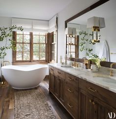 a bathroom with a large white bathtub sitting next to a sink and two windows