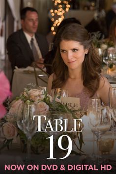 a woman sitting at a table with wine glasses