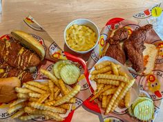 two trays filled with different types of food on top of a wooden table next to each other