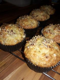 several muffins sitting on top of a wire rack next to a wooden table