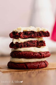 three red velvet cookies stacked on top of each other with white frosting and icing