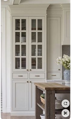 a kitchen with white cabinets and wooden floors