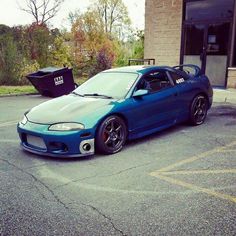 a blue sports car parked in front of a building