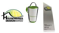 a green and white award for housewares design awards is shown next to the trophy