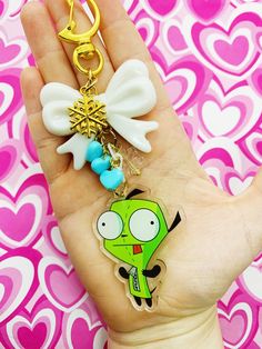 a hand holding a keychain with a cartoon character on it