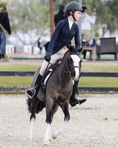 a woman riding on the back of a brown and white horse