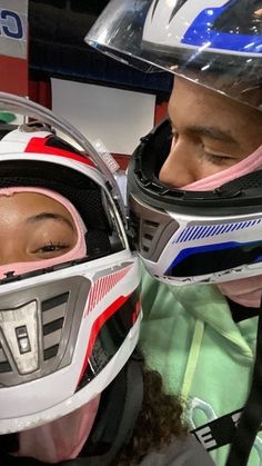 two people with helmets on their heads looking at each other