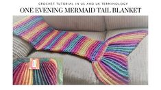 a knitted mermaid tail sitting on top of a couch next to a pillow with a tag