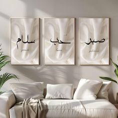 three framed arabic calligraphys hang on the wall above a couch