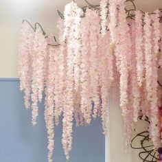 pink flowers hanging from the ceiling in a room