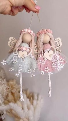 two little angel ornaments hanging from a string