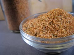 a glass bowl filled with ground spices next to a jar full of seasoning powder