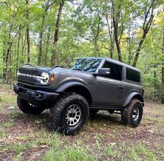 a large gray truck parked in the woods