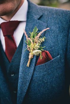 a man wearing a suit and tie with a boutonniere on his lapel