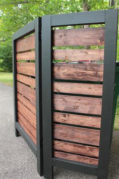 a wooden fence with black slats on the sides and green trees in the background