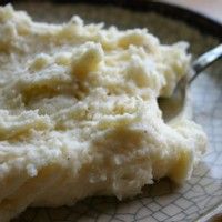 mashed potatoes on a plate with a spoon