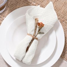 a white plate topped with two napkins and flowers