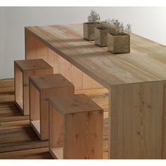 three wooden planters sitting on top of a wood shelf next to eachother