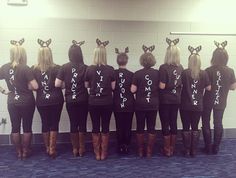 a group of women standing in front of a mirror wearing bunny ears on their shirts