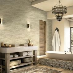 a bath room with a tub a sink and a rug on the floor in front of a window