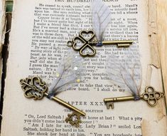 an open book with antique keys attached to it