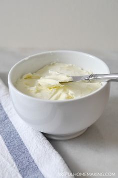 a white bowl filled with whipped cream on top of a blue and white striped towel