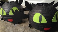 two black paper lanterns with green eyes and fangs